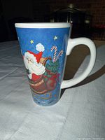 Left side view showing Santa in sleigh graphic on tall ceramic mug