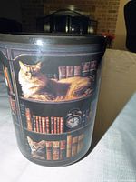 Front view of mug showing cat lounging on bookshelf with clock and books