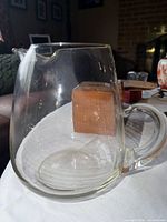 Full view of clear glass pitcher on tabletop