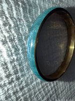 Side view of blue enamel and gold-tone bangle