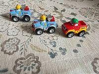 Three Tonka mini trucks on fabric surface