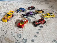 Group of eight Hot Wheels cars on fabric surface