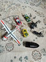 All seven toy vehicles laid out on patterned surface