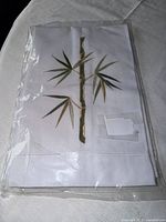 Front view of packaged white towel showing bamboo embroidery
