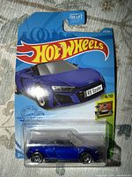 Front of blister card showing blue Audi R8 Spyder car and Hot Wheels graphics