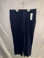 Full view of navy Charter Club dress pants hanging, tags visible