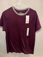Front view of burgundy Goodfellow ringer T-shirt on hanger