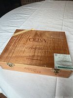 Closed cigar box top view showing branding, corner band, tax seal