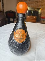 Front view showing full bottle, wood cap, label visible
