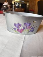 Front view of planter showing painted crocus flowers and bee