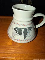 Side view showing cow illustration, floral border, overall shape