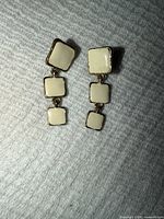 front view showing cream enamel squares and gold tone frames