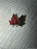 Front view showing red and green enamel maple leaves