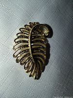 Front view of gold-tone leaf brooch