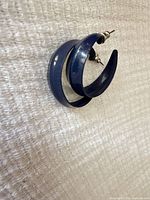 Front angle showing both navy blue enamel hoop earrings