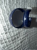 Front view of two navy blue enamel half-hoop earrings together