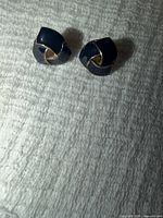 front view showing navy enamel and gold-tone swirl design