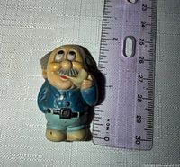 Front view of plastic Grandpop magnet beside ruler showing height