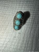 Top view of ring showing three turquoise stones and filigree design