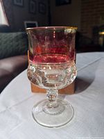 Front view of clear pressed glass goblet with ruby stained top