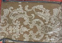 Close-up of brown/cream damask fabric and packaging