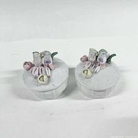 Two matching porcelain trinket dishes with fairies and roses on lids, closed