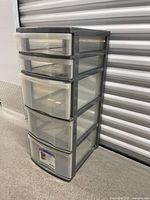 Angled view of grey framed five-drawer tower