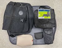 Top view of all items: messenger bag, Protege travel set, beige toiletries pouch, black pouches