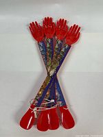 Four red plastic back scratcher / shoe horns crossed