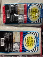 Two sealed plastic drop sheet packages stacked, showing overall lot