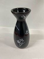 Front view of black ceramic bud vase showing floral details