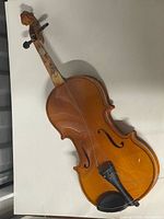 full view of violin front showing loose strings and overall condition