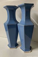 Front view of both blue faceted vases standing side by side