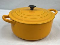 Side view showing saffron exterior enamel, handles, lid