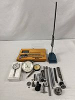 Overview of all items laid out: caliper in case, dial indicators, stand, rods and fittings