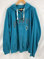 Front view of teal San Jose Sharks full-zip hoodie on hanger
