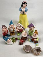 Group view of Snow White, seven dwarf figures, two geode halves