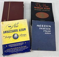 All four albums standing: Ambassador (with slipcase), Modern, New World Wide, maroon stock book
