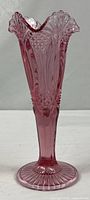 Full view of cranberry pressed glass footed bud vase