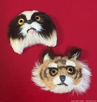 Front view of both cat face brooches