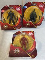 Group shot of three sealed The Flash movie action figures: Batman, Dark Flash, The Flash
