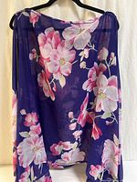 Front view of floral charmeuse blouse on hanger