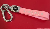 Full keychain showing pink leather strap with Lincoln text and silver-tone clip