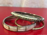 Three bangles stacked showing shell inlay and stone-accented piece