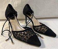 Full side view of both pumps showing lace, heels, ankle ties