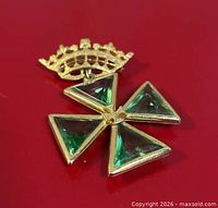Front view of brooch showing crown and green glass Maltese cross