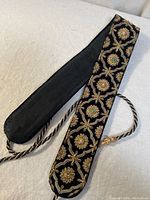 Full view of belt showing embroidered face, lining and braided tie cords