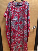 Full view of red and grey patterned kaftan dress on hanger