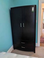 Front view of dark wood armoire closed