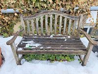 Front view of weathered wooden bench showing full form and slatted design